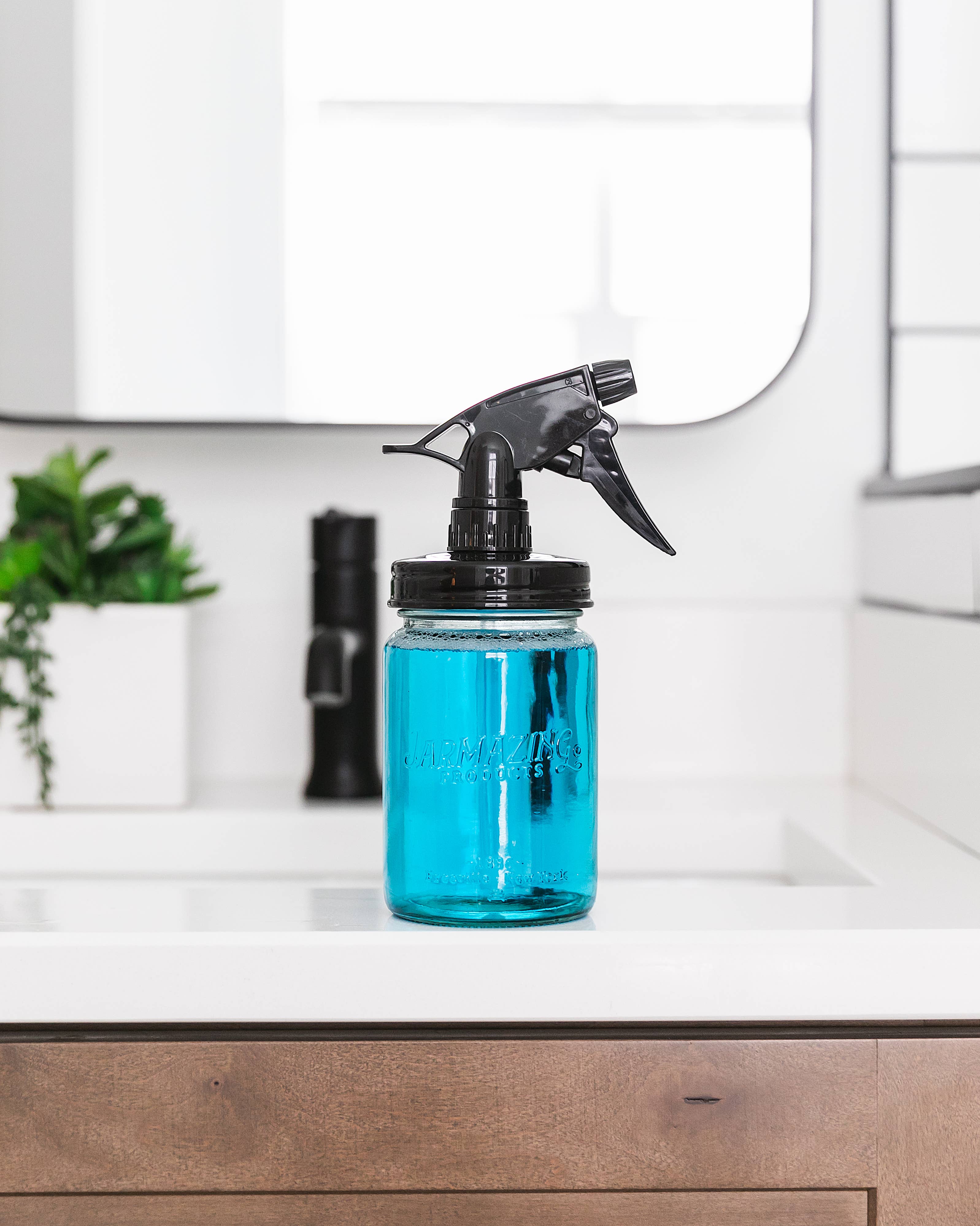 Blue glass mason jar sprayer in use